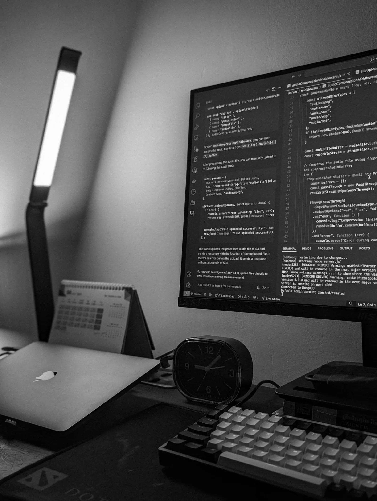 Computer monitor showing terminal output and system logs in an engineering workspace